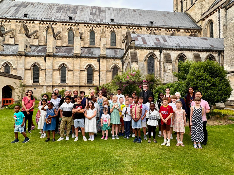 People gathered on lawn outside cathedral.