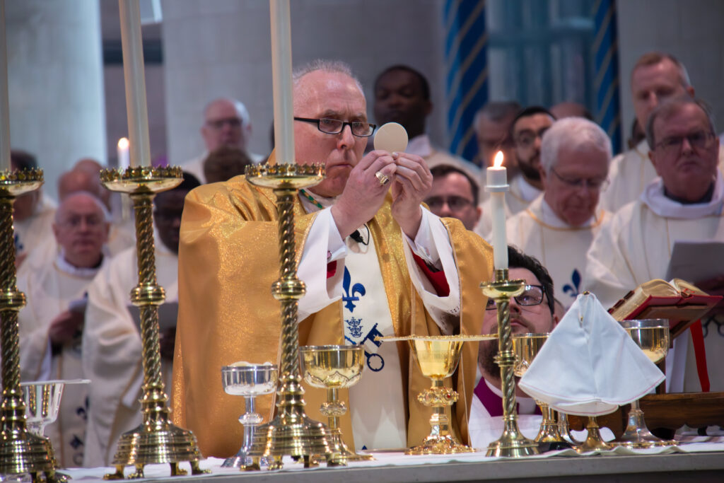 Bishop holding wafer in cathedral mass.