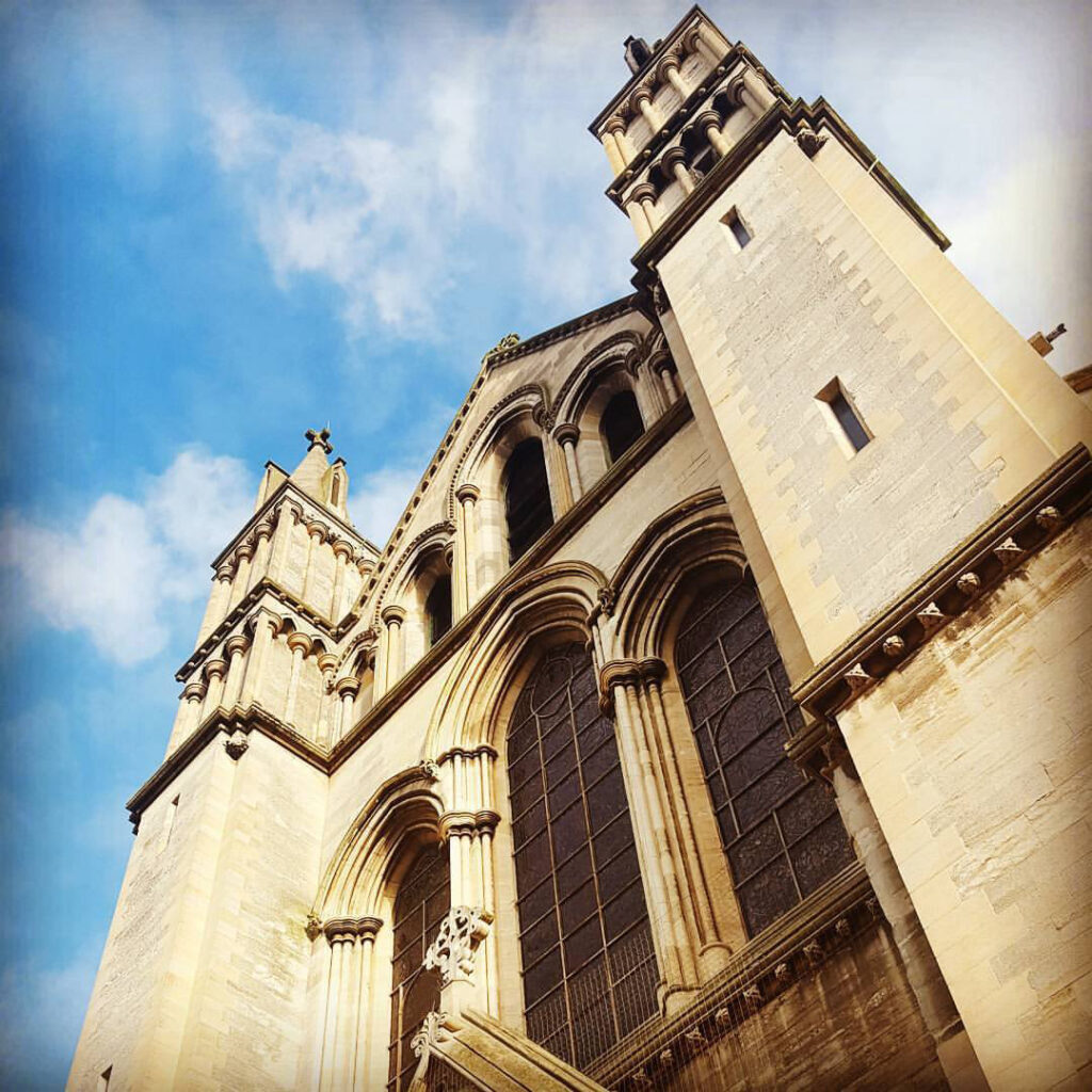 View of outside of St John the Baptist Cathedral, looking up into blue sky above.