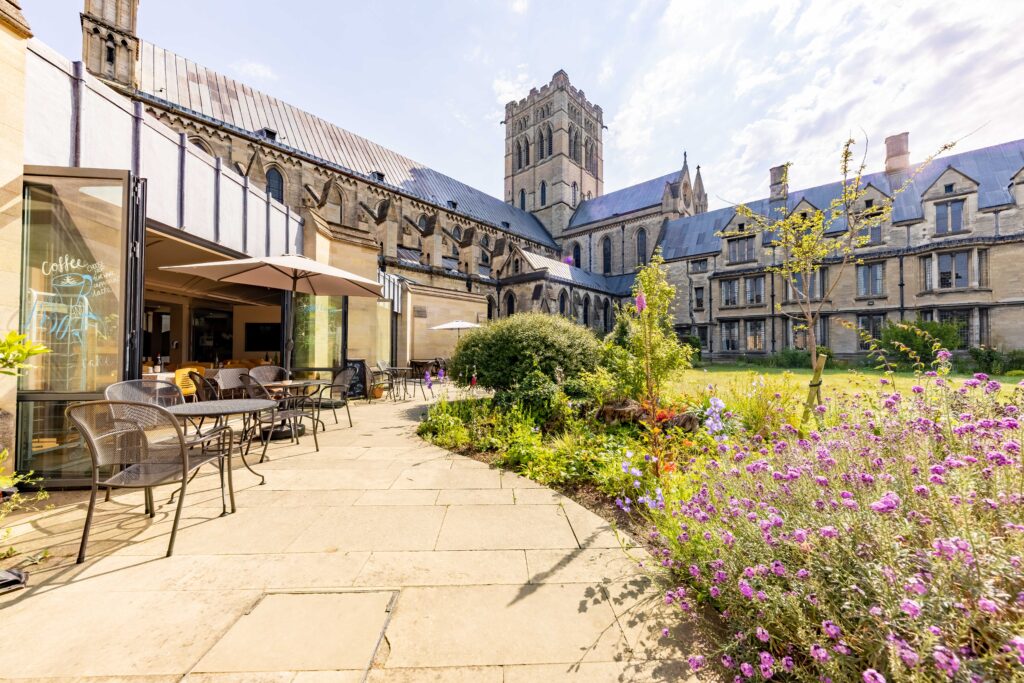 St John the Baptist Cathedral with tables on patio of café.