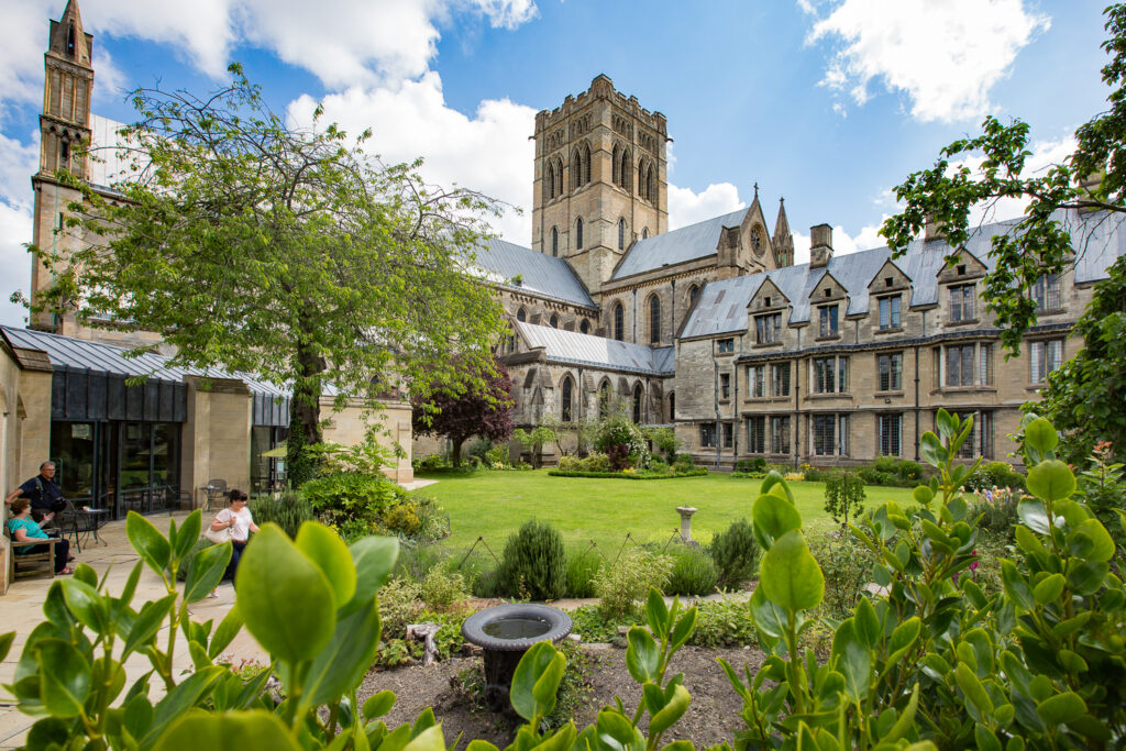 St John the Baptist Cathedral in background with green grass and plants in foreground.