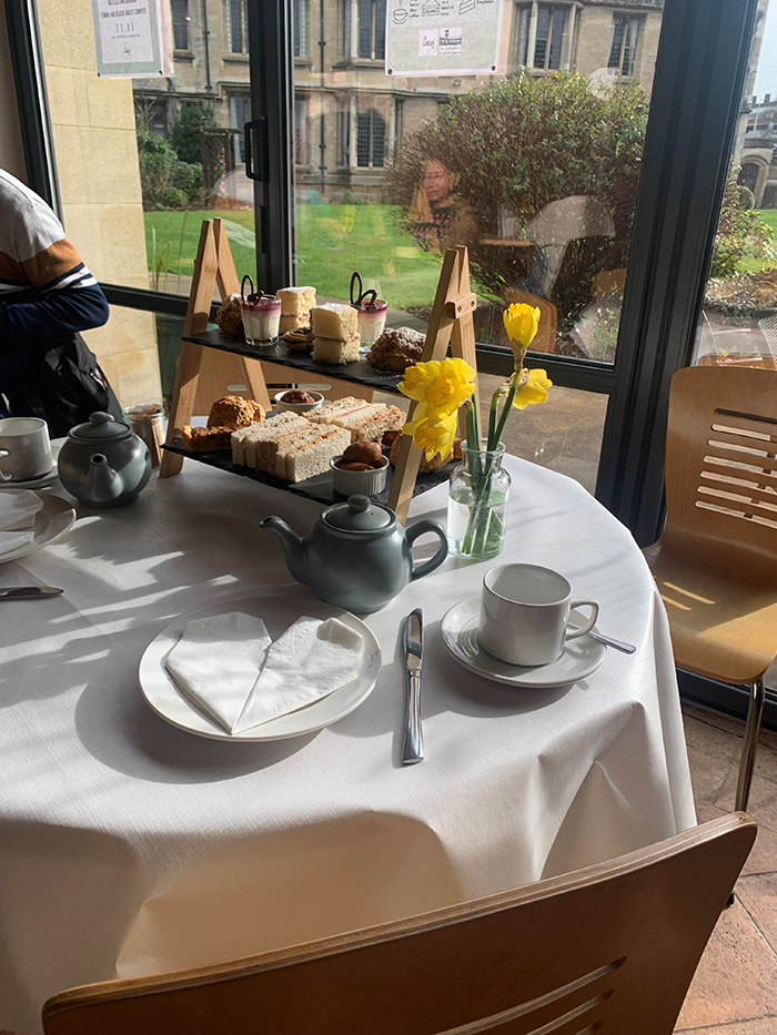 Café table with daffodils and afternoon tea.