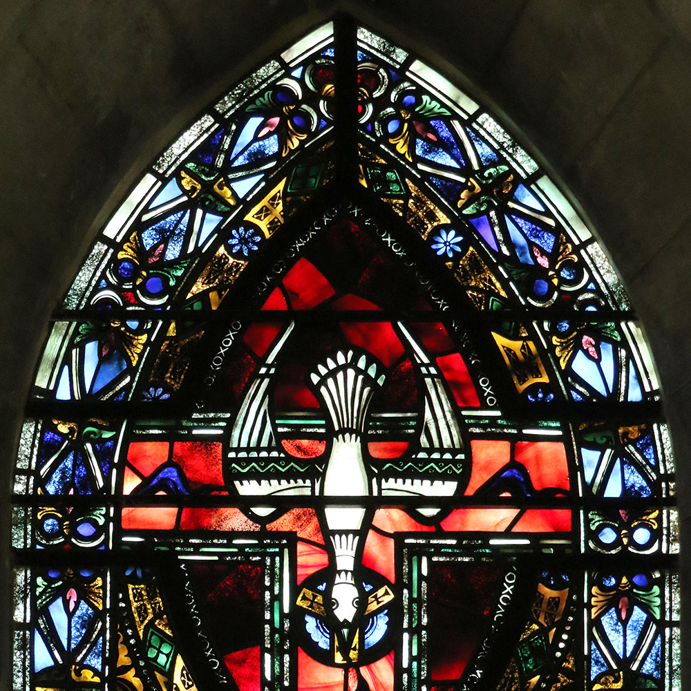 Stained glass window depicting religious scene of dove.