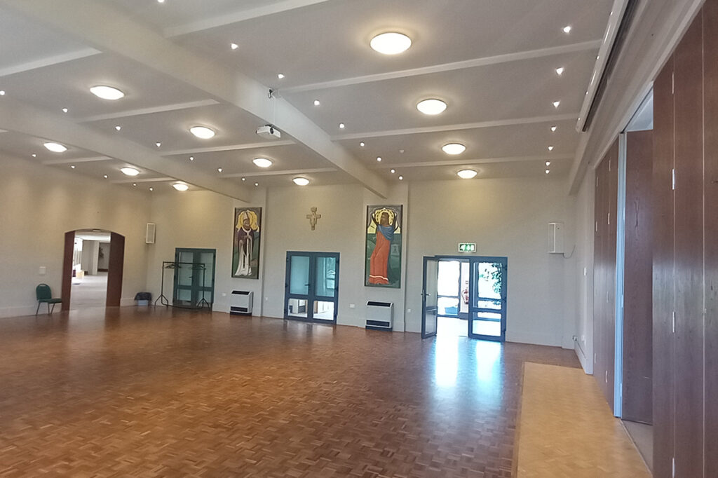 Large hall area with wooden floors and double doors.