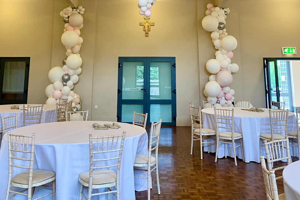 Wedding tables and white balloons decorating a hall