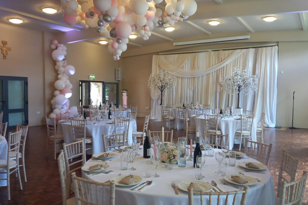 Wedding tables and white balloons decorating a hall